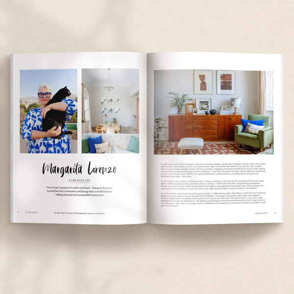Open pages of 91 Magazine Issue 18 featuring Margarita Lorenzo and her creative home, with colourful artwork, vintage furniture and a green armchair.