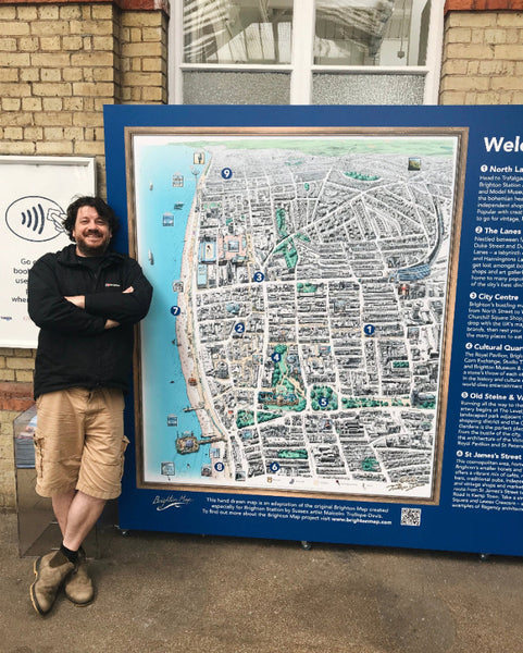 Brighton Station wayfinding map created by artist Malcolm Trollope-Davis, who is standing in front of it.