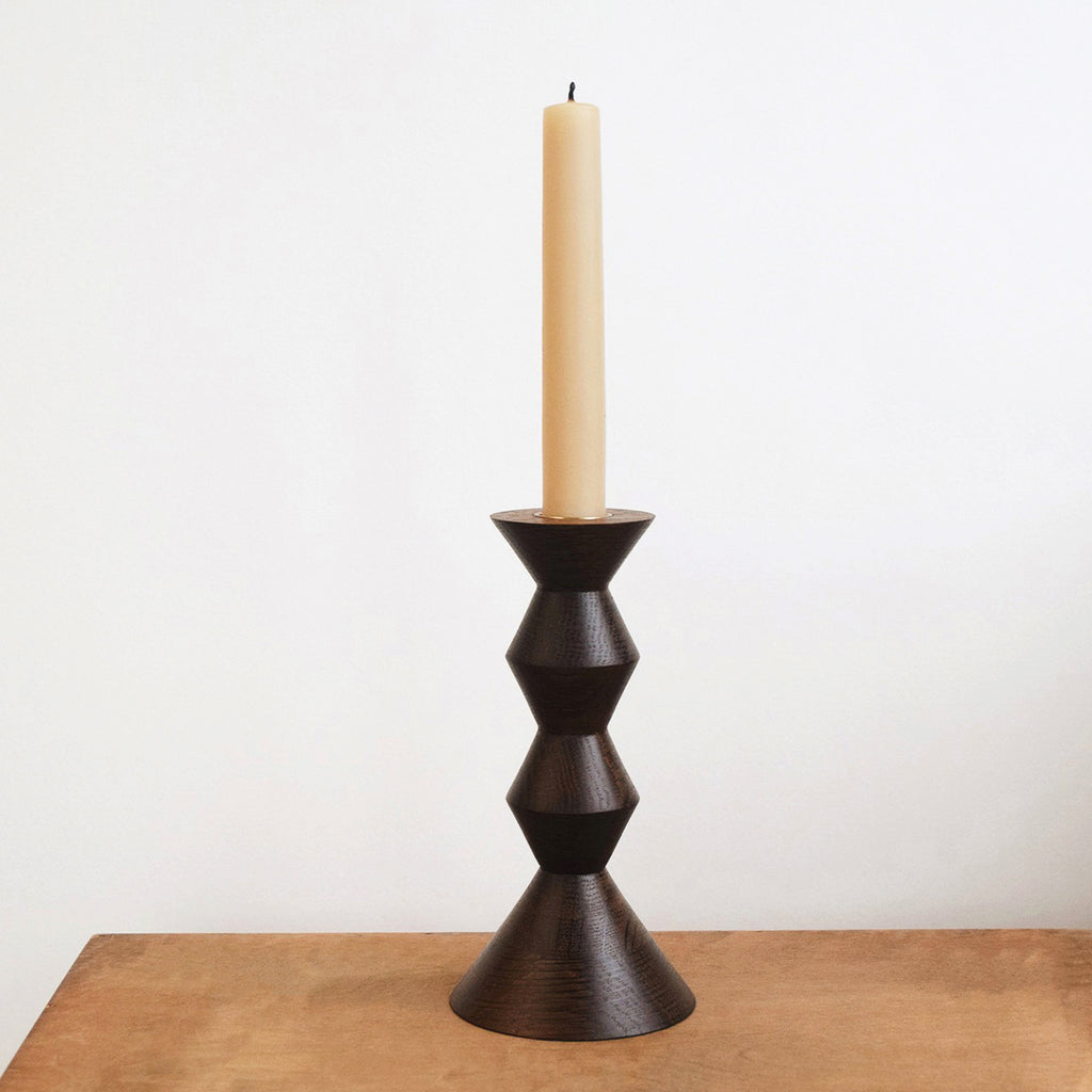 Fumed oak candlestick by Selwyn House with a dark brown finish and beeswax dinner candle