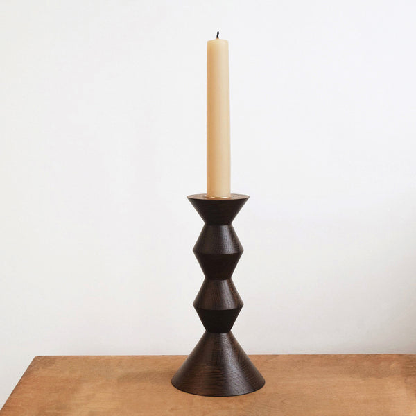 Fumed oak candlestick by Selwyn House with a dark brown finish and beeswax dinner candle