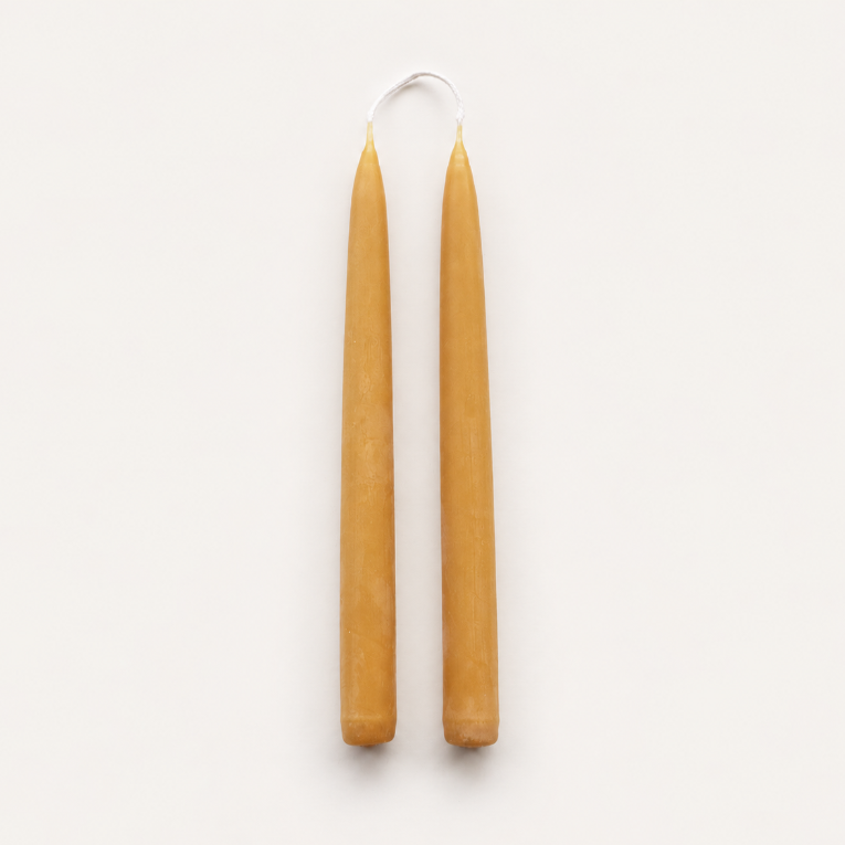 A pair of natural beeswax taper candles handmade from pure British beeswax in Cumbria UK.