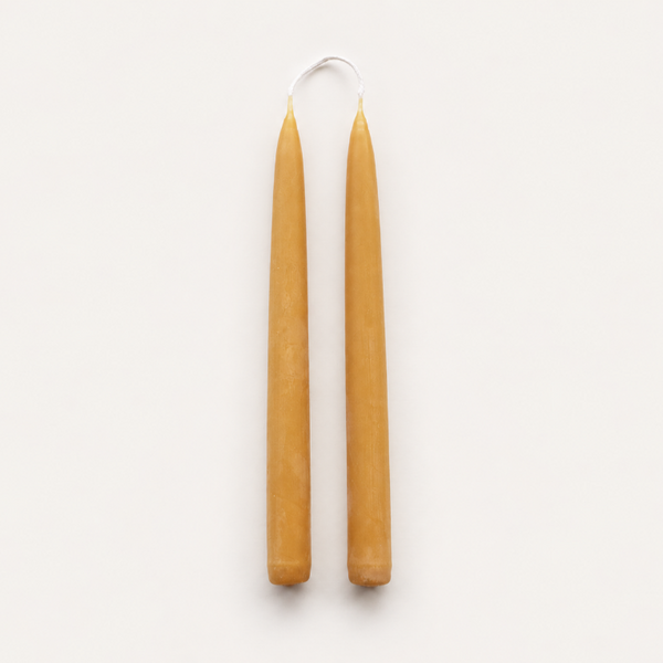 A pair of natural beeswax taper candles handmade from pure British beeswax in Cumbria UK.
