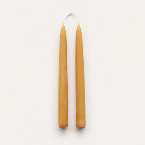 A pair of natural beeswax taper candles handmade from pure British beeswax in Cumbria UK.