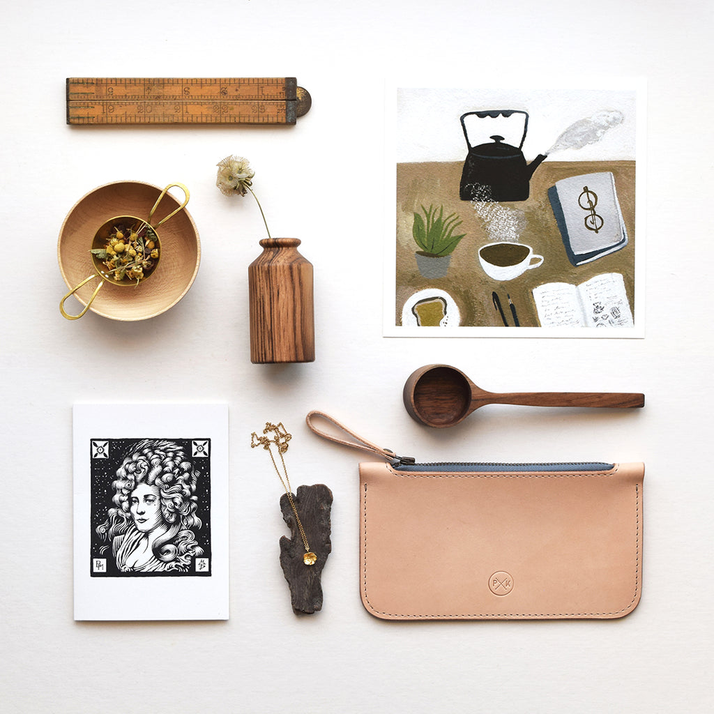 Lewes Map Store E-Gift Voucher styled with handmade gifts, including wooden homeware, a leather pouch, jewellery, artwork and a magazine.