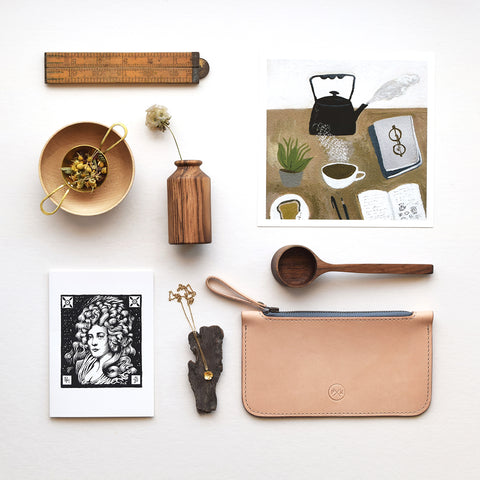 Lewes Map Store E-Gift Voucher styled with handmade gifts, including wooden homeware, a leather pouch, jewellery, artwork and a magazine.