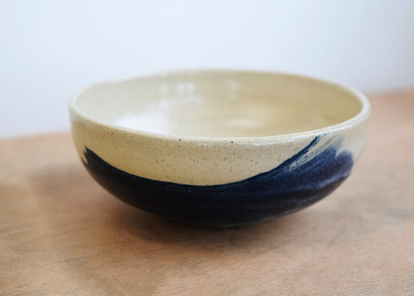Side view of a hand-thrown stoneware bowl with indigo and white glaze