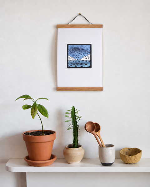 Starling Murmurations Brighton fine art print displayed on a wall with plants and handmade homeware