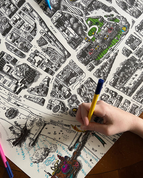 Person colouring the Brighton Map poster with Brighton Palace Pier visible on the map