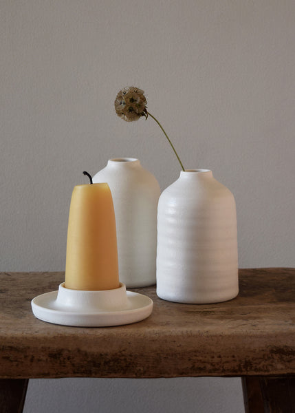 Porcelain Bottle Vase and Porcelain Candle Holder wheel thrown by Katie Robbins in her Birmingham studio. Glazed in a matt chalky finish with the makers’ unique leaf stamp on the bottom.