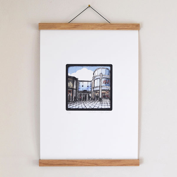 Churchill Square Brighton fine art print displayed in an oak poster hanger