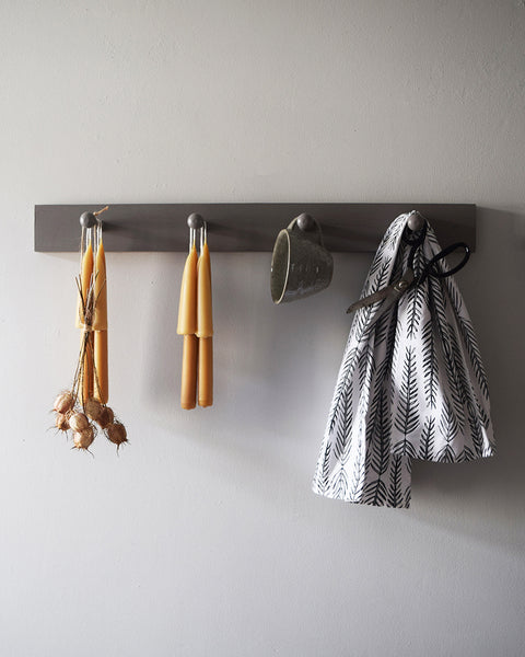 Hand-dipped English beeswax Stubby candles hanging on a wall rack