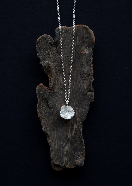 Hawthorn Blossom silver necklace displayed on natural wood by Alice Stewart Jewellery