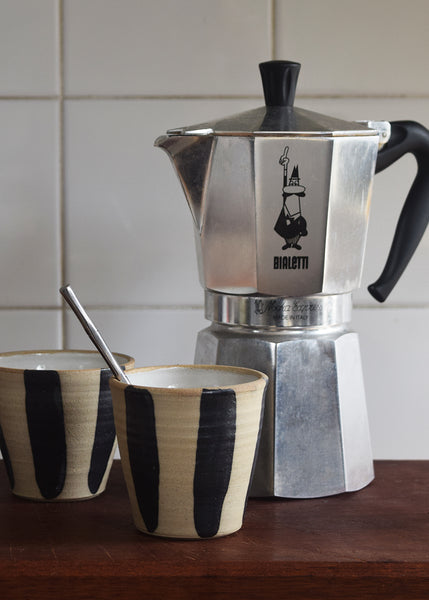 Indigo stripe stoneware beaker filled with coffee