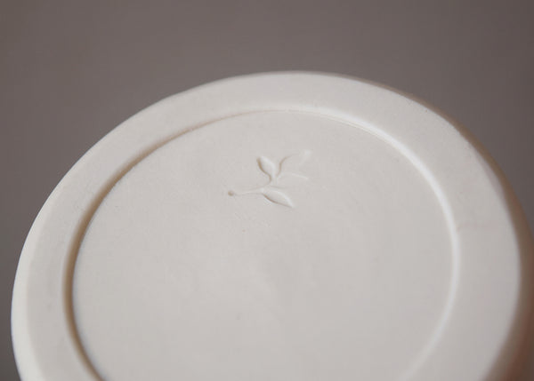 Porcelain Bottle Vase wheel thrown by Katie Robbins in her Birmingham studio. Glazed in a matt chalky finish with the makers’ unique leaf stamp on the bottom. Perfect for single stem flowers, small posies and seed heads. 