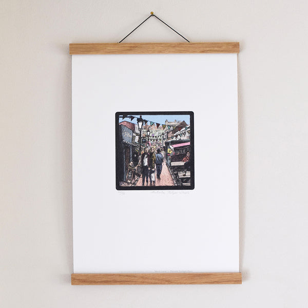‘North Laine’ is part of the ‘Brighton Icons’ collection. A series of limited edition art prints numbered 1 to 75 signed by the artist Malcolm Trollope-Davis and produced as an A3 giclee print. North Laine has a happening, bohemian vibe with vegetarian cafes, vintage clothing stores, and jewellery stalls centred on busy Kensington Gardens pedestrian road.