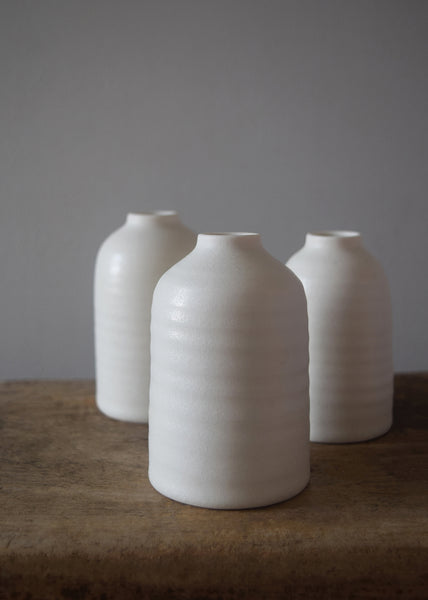 Porcelain Bottle Vase wheel thrown by Katie Robbins in her Birmingham studio. Glazed in a matt chalky finish with the makers’ unique leaf stamp on the bottom. Perfect for single stem flowers, small posies and seed heads. 