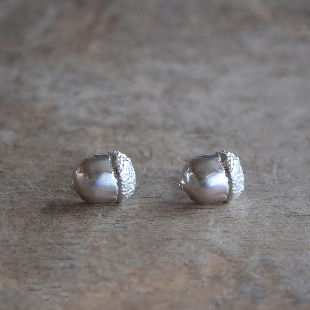 Silver acorn earrings by Alice Stewart Jewellery, handcrafted from solid sterling silver on a natural wood surface